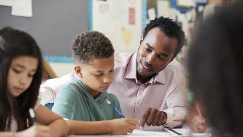 students doing work with teacher's help